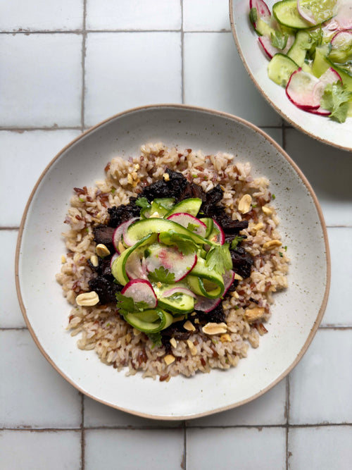 Slow-cooked beef and brown rice bowl with cucumber ribbons, radish, coriander and peanuts
