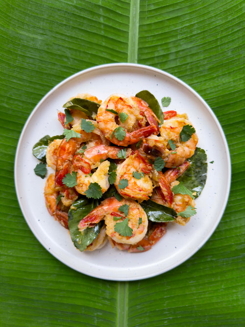 Prawns with coriander and chilli, served on a plate over a banana leaf